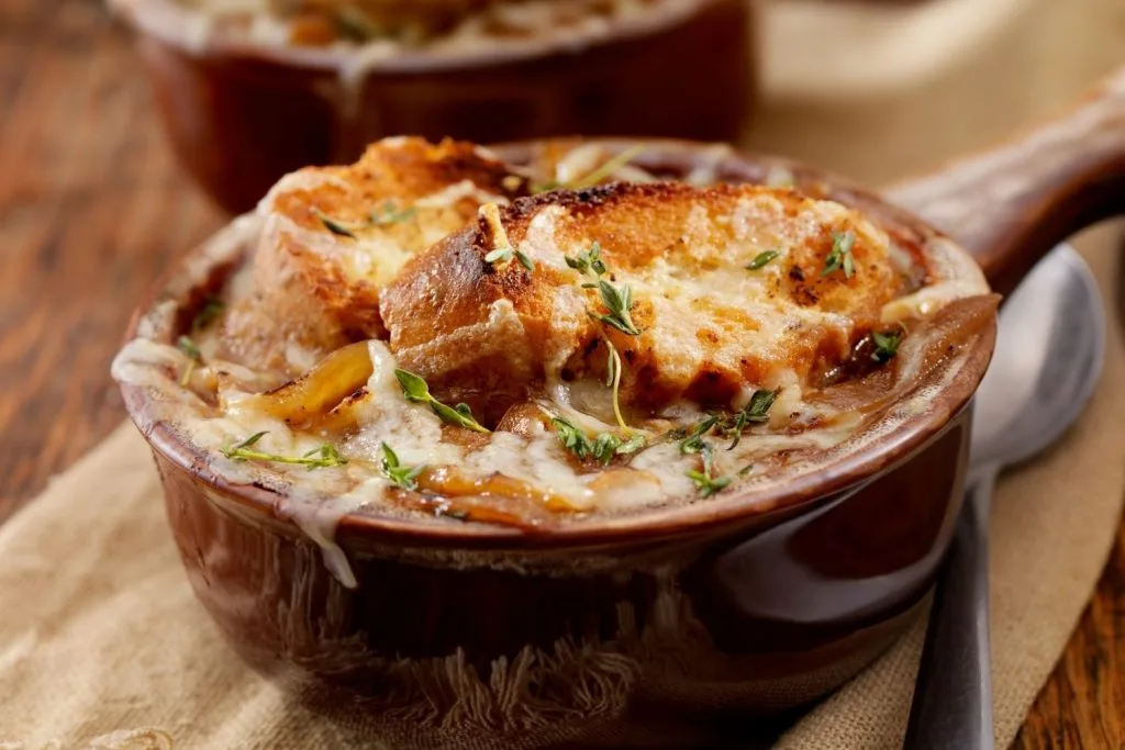 bol de soupe à l'oignon gratine avec des herbes