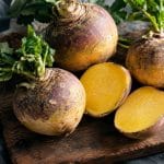 rutabaga entier et coupé sur planche en bois, chair jaune vif