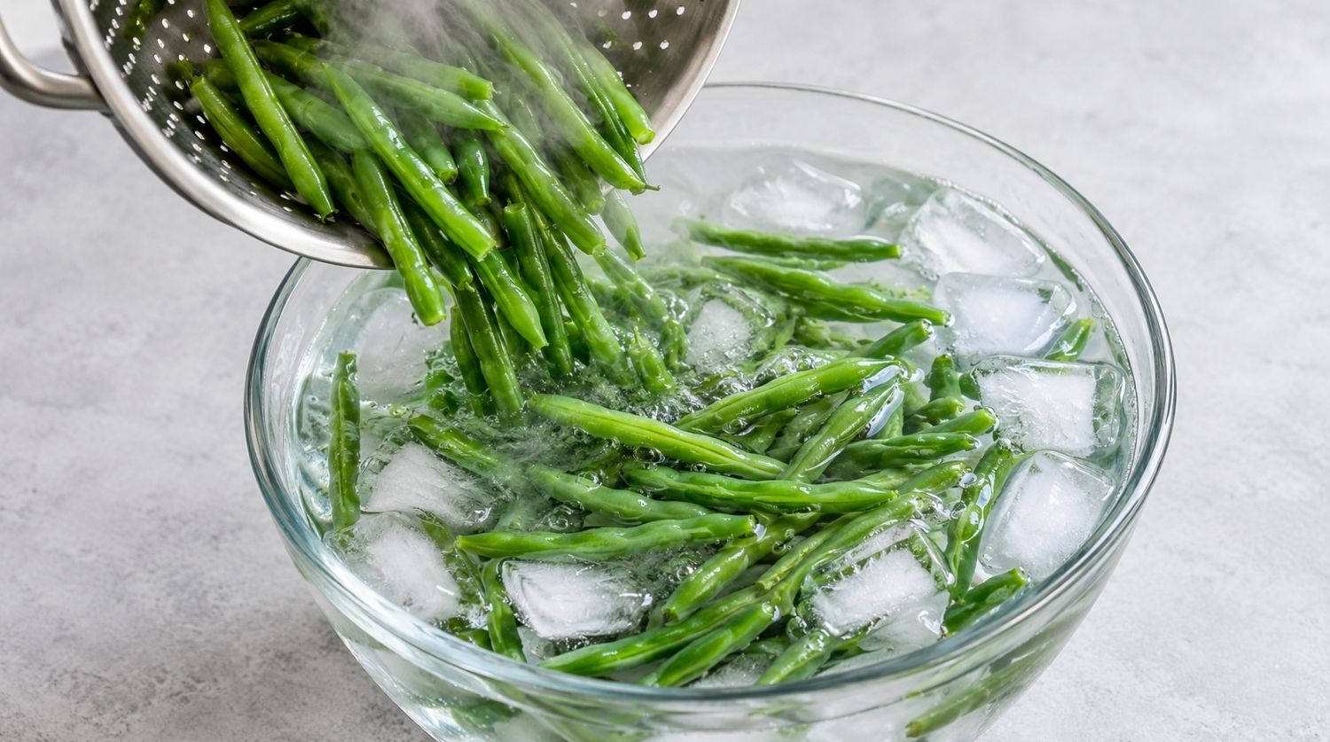 haricots verts versés dans un saladier d’eau glacée